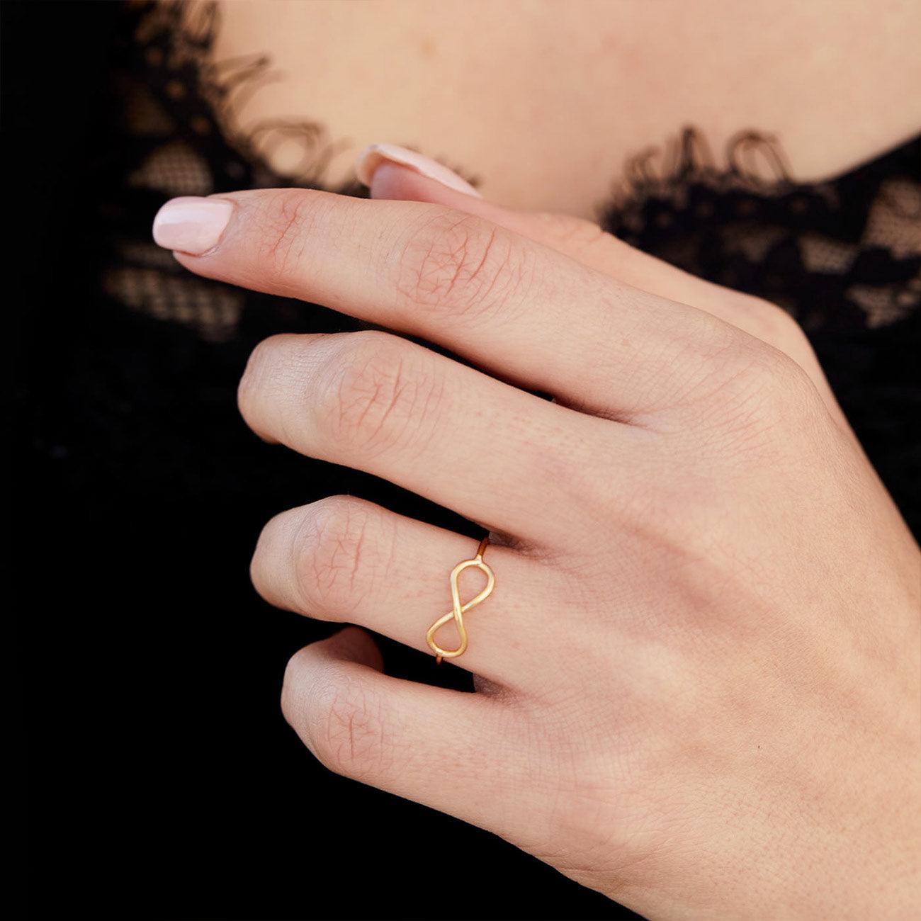 Hand mit Infinity Goldring