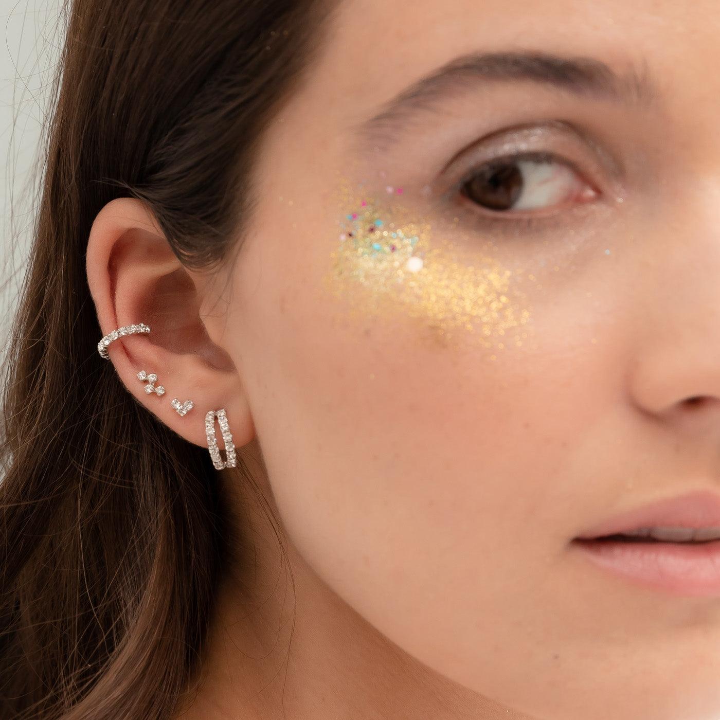 Woman with silver earrings with white zircons