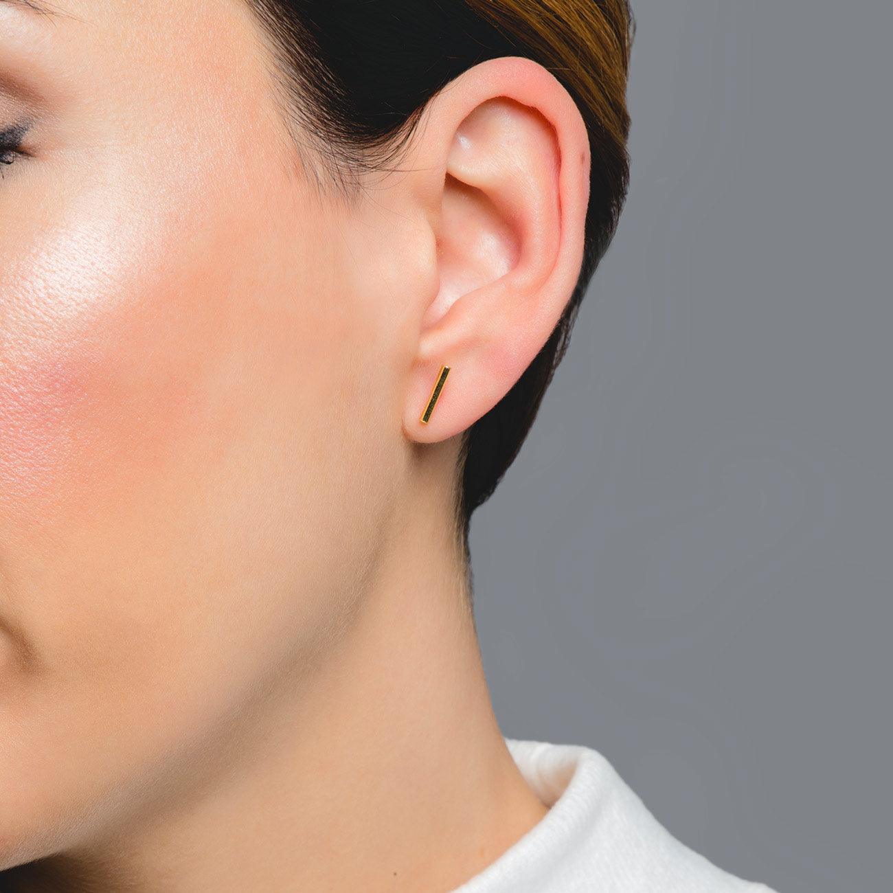 Woman with Stick Gold earring. Adamina