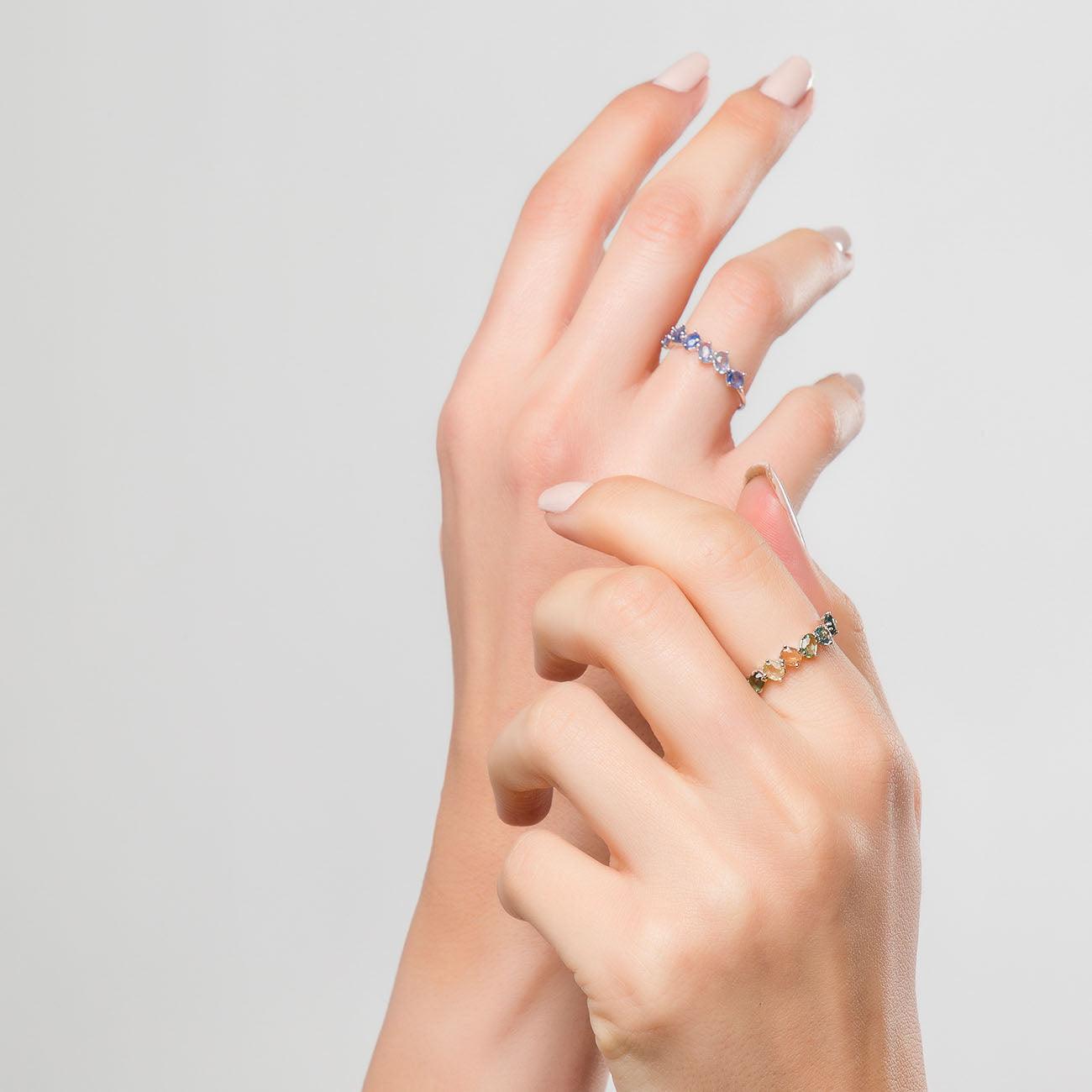 Mano con due anelli d'argento blu zaffiro