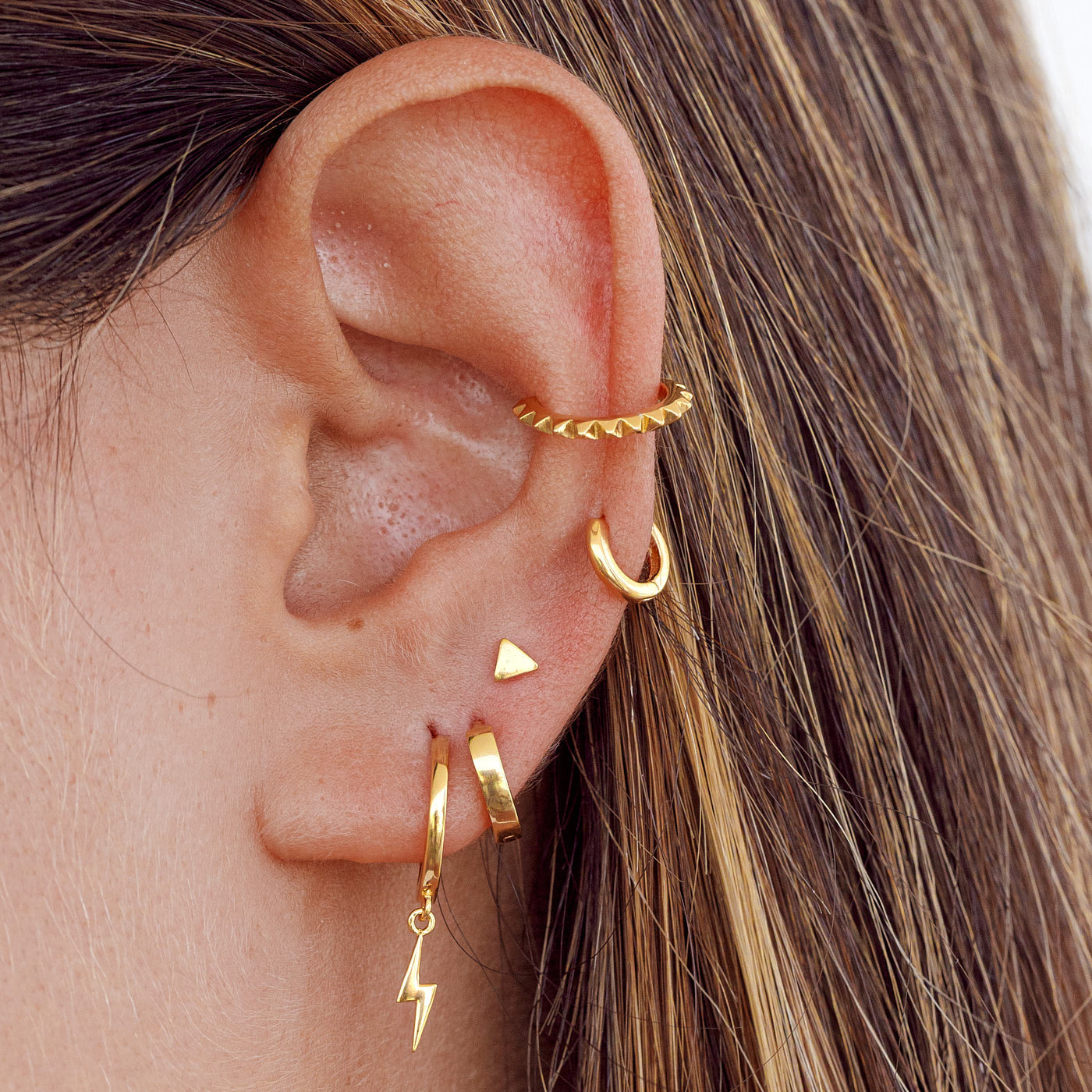 Oreja con pendiente Triangle Gold y otros pendientes de oro de diferentes formas