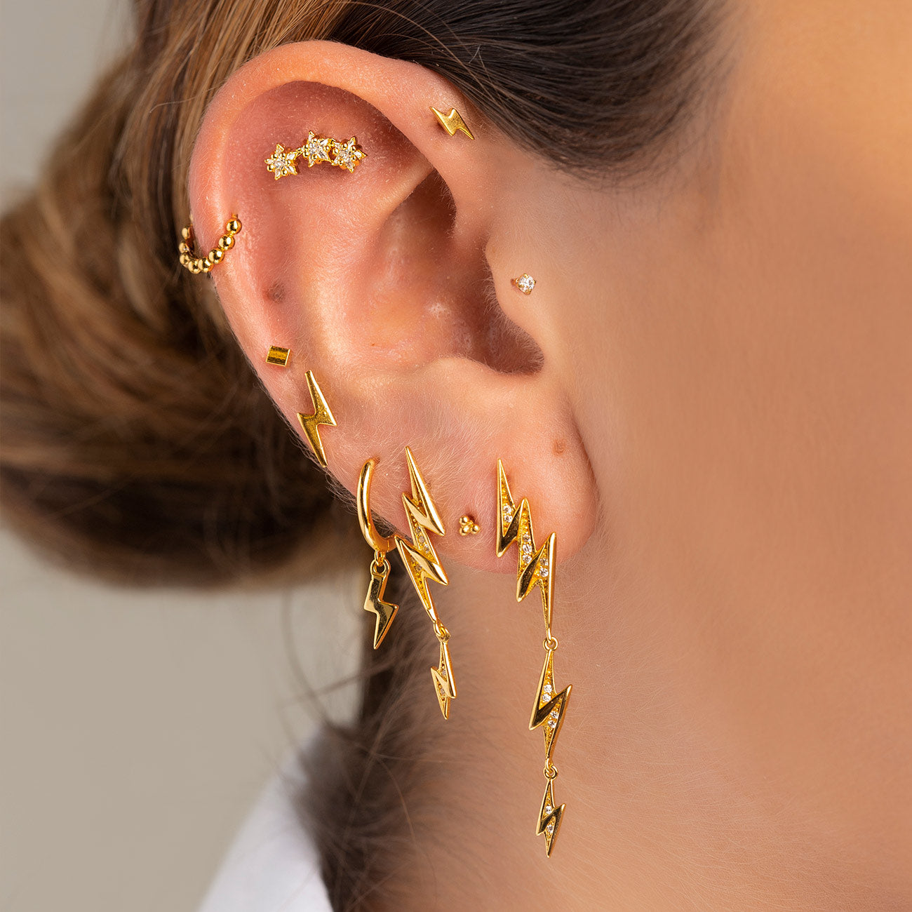 Oreja de mujer con diferentes pendientes de oro de la colección de Adamina